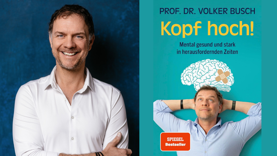 Volker Busch schaut in die Kaera, daneben sein Buch Kopf hoch!